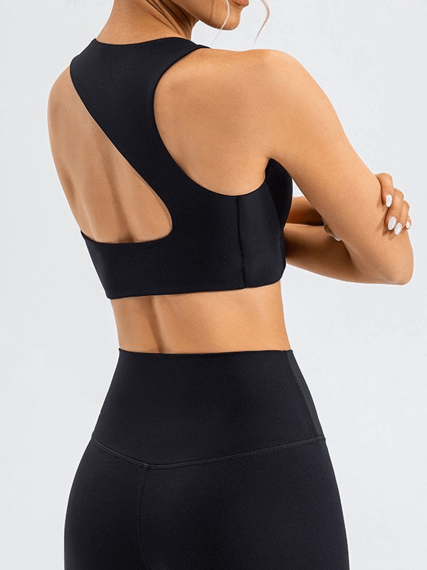 Woman wearing a black open back sports bra, perfect for workouts and fitness activities, showing stylish and breathable design.
